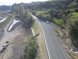 A road with a car driving down it

AI-generated content may be incorrect.